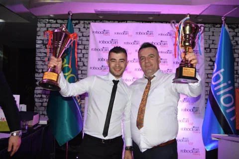 Two participants celebrating with trophies