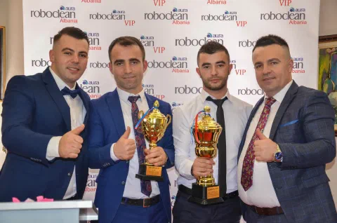 Participants holding trophies in front of a Roboclean backdrop