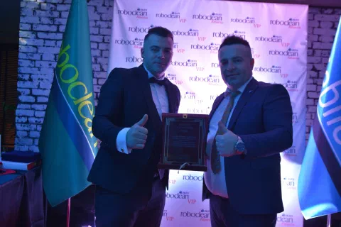Two participants holding an award plaque