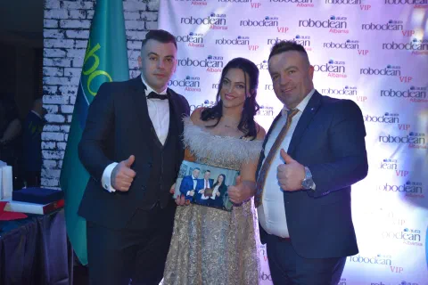 Three participants posing with an award