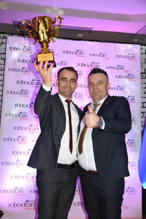 Participant raising a trophy at a ceremony