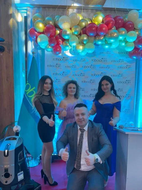 Guests posing beside Roboclean products