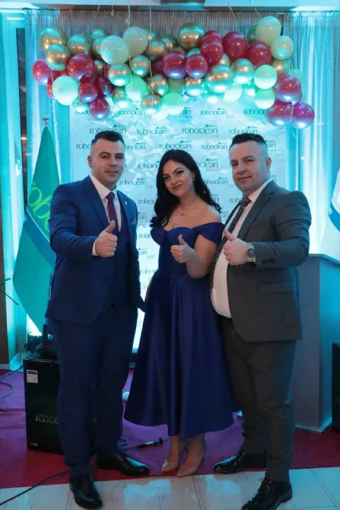 Three guests beside a balloon backdrop