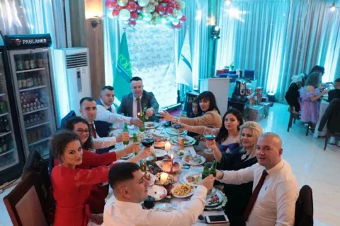 Participants smiling beside a table