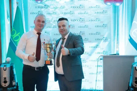 Two participants holding a trophy
