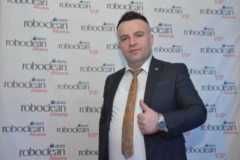 Representative in a suit before a Roboclean backdrop